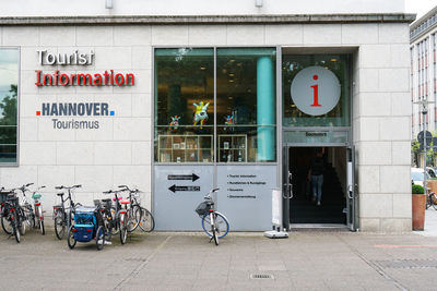 Bicycle sign on street against building in city