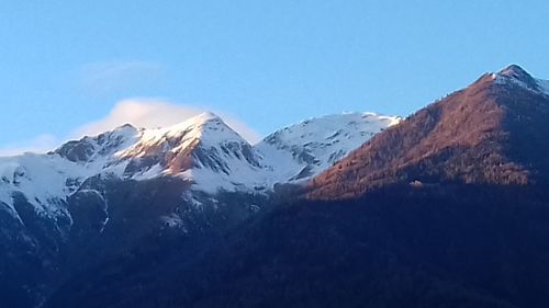 Scenic view of snowcapped mountains against clear blue sky