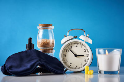 Close-up of clock on table against blue background