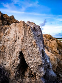 Close-up of rock formation in sea against sky