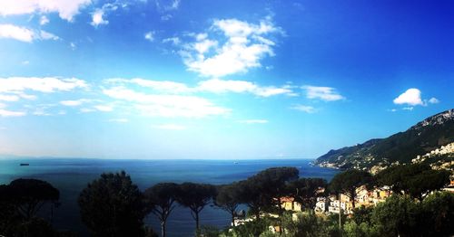 Scenic view of sea and mountains against blue sky