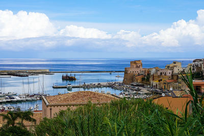 Scenic view of sea by buildings against sky