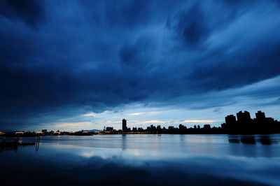 Panoramic view of sea and buildings against sky at sunset