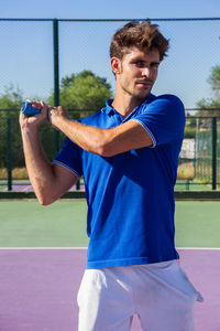 Portrait of man playing tennis at court