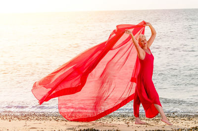 Portrait of mature woman with red scarf on beach