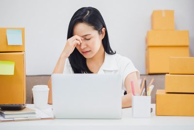 Young woman using phone while sitting on table