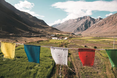 Clothes drying on field against mountains