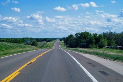 Road amidst trees against sky