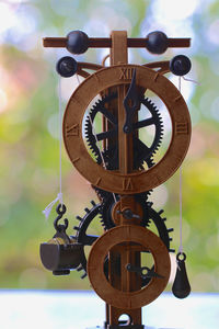 Close-up of clock hanging on wood