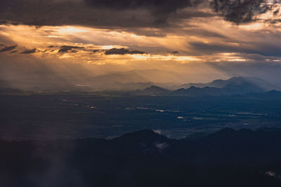 Scenic view of silhouette mountains against dramatic sky