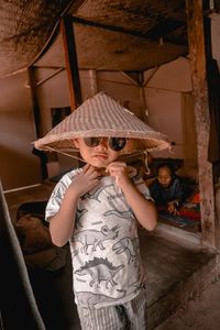 Boy wearing conical hat standing at home