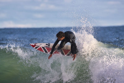 Man surfing on sea against sky