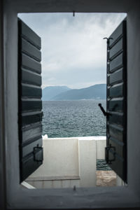 Scenic view of sea against sky seen through open window