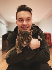 Portrait of smiling young woman with cat