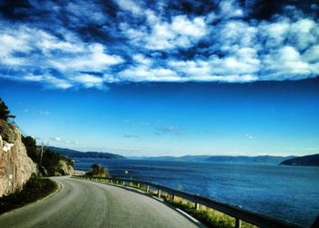 Empty road against cloudy sky