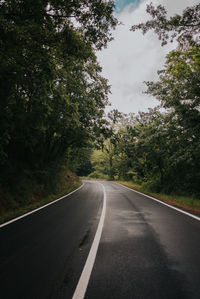 Road amidst trees against sky