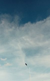 Low angle view of street light against cloudy sky