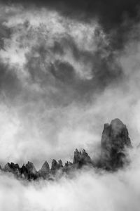 Dolimiti rocky mountain peaks covered with dramatic clouds in the evening.