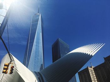 Low angle view of skyscrapers against blue sky