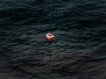 High angle view of shirtless man swimming in sea