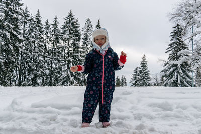 Little girl of 4 yo is playing in the snow