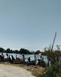 People on beach against clear sky