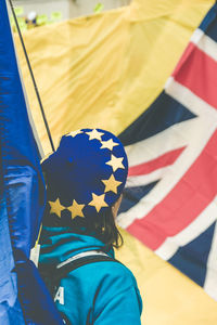 Rear view of man standing against yellow umbrella