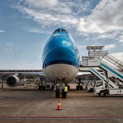 Airplane on airport runway against sky