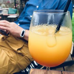 Close-up of hand holding drink on table