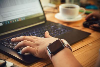 Midsection of man using laptop on table