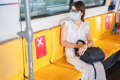 Full length of woman holding yellow train