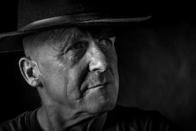 Close-up of man looking away while wearing hat