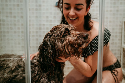 Smiling woman washing dog