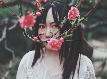 Portrait of woman by flowering plant