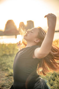 Young woman with arms raised