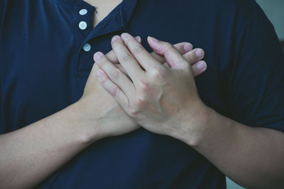 Midsection of couple holding hands