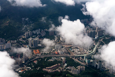 Aerial view of cityscape against cloudy sky