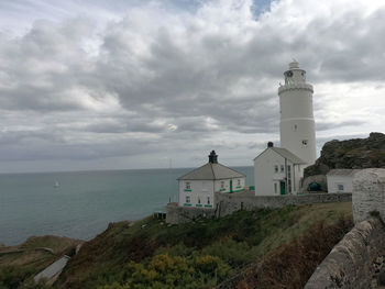 Lighthouse by sea against sky at start point