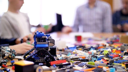 On the table there are scattered a lot of details from the children's designer, cubes, wires, boards