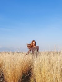 Full length of woman on grass in field against sky