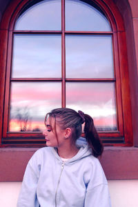 Girl looking through window