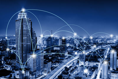 Illuminated buildings in city against sky at night