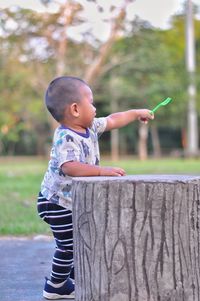 Side view of cute boy standing outdoors