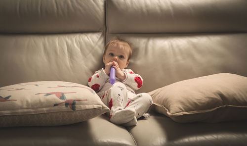 Portrait of cute baby lying on bed at home