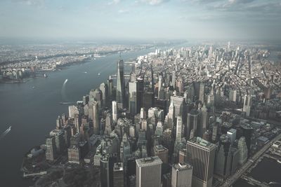 Aerial view of new york city by sea against sky