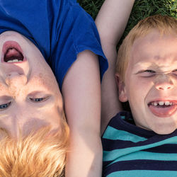 Portrait of smiling boys lying on grass