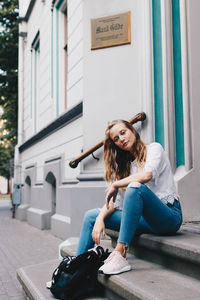 Portrait of smiling young woman against built structure