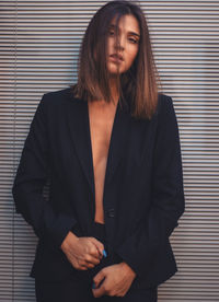 Portrait of woman standing against wall