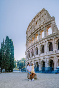 Rear view of couple embracing against amphitheater