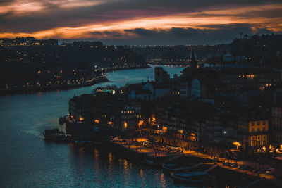 High angle view of city lit up at sunset